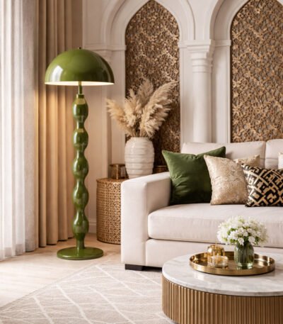 Olive green sculptural floor lamp placed in a luxury living room with beige sofa, decorative pillows, and Islamic-inspired wall panels.